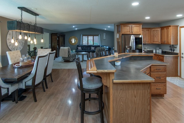 5360 Marohn Rd, Baxter, MN 56425 - kitchen with stainless steel fridge, light wood-style floors, a kitchen island, and lofted ceiling