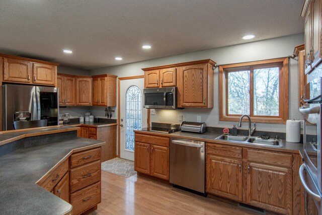5360 Marohn Rd, Baxter, MN 56425 - kitchen featuring brown cabinets, a sink, stainless steel appliances, light wood-type flooring, and visible vents