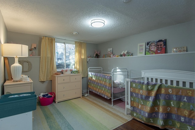 5360 Marohn Rd, Baxter, MN 56425 - bedroom with a nursery area, a textured ceiling, and wood finished floors