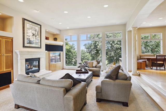 living room with a premium fireplace, ornate columns, and recessed lighting