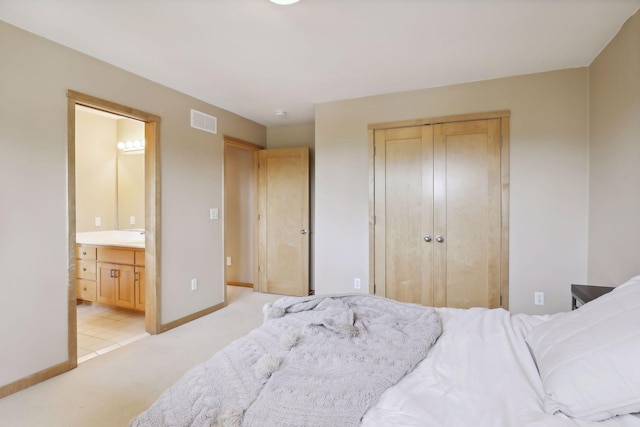 bedroom with light colored carpet, visible vents, baseboards, a closet, and connected bathroom
