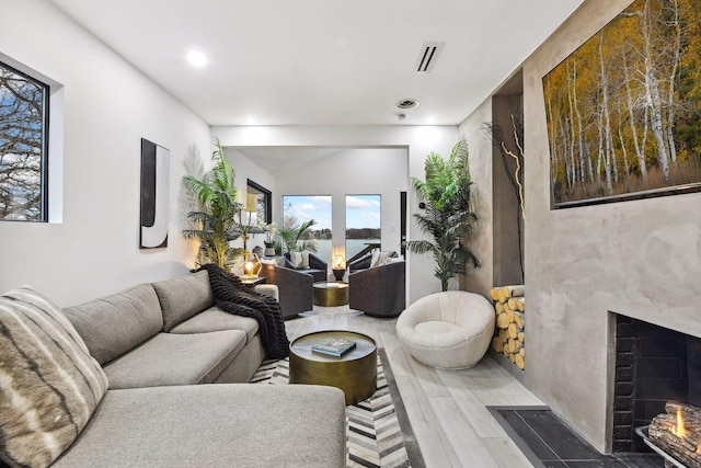 living area with a fireplace, recessed lighting, and visible vents