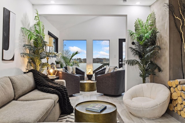 interior space featuring recessed lighting, vaulted ceiling, and a water view