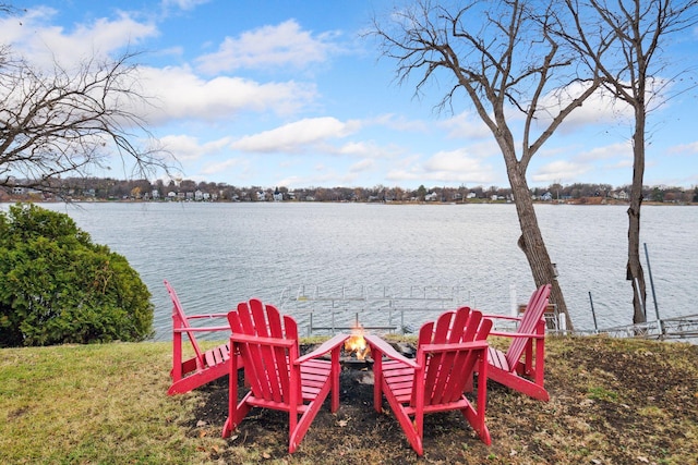 exterior space featuring a water view and a fire pit
