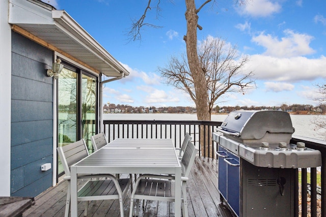 wooden terrace featuring outdoor dining area, a water view, and grilling area