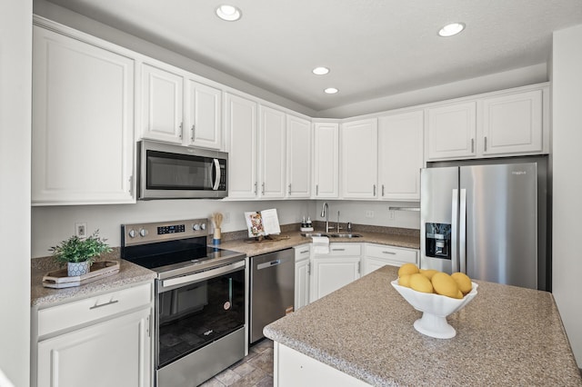 kitchen with recessed lighting, a sink, white cabinetry, and appliances with stainless steel finishes