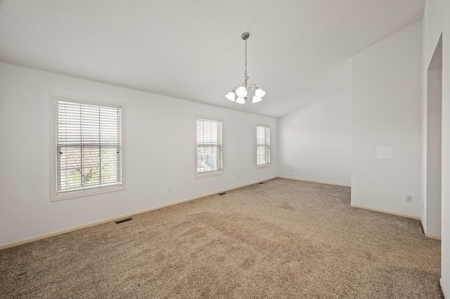 spare room featuring visible vents, vaulted ceiling, carpet floors, baseboards, and an inviting chandelier
