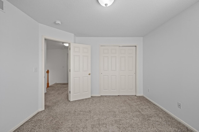 unfurnished bedroom featuring carpet flooring, baseboards, visible vents, and a closet