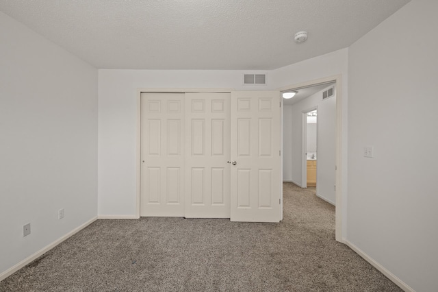 unfurnished bedroom with a closet, baseboards, carpet flooring, and visible vents