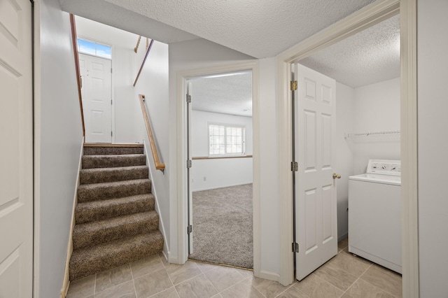 staircase with washer / dryer, tile patterned flooring, and a textured ceiling