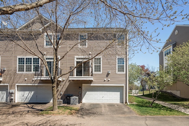 view of front of house with a garage, central AC, and driveway