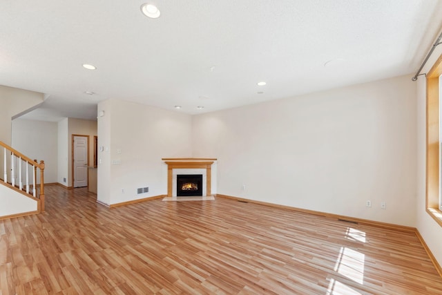 unfurnished living room featuring recessed lighting, stairway, visible vents, and light wood finished floors