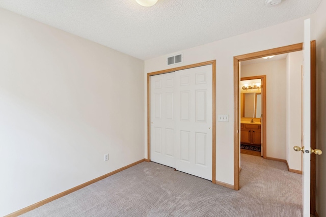 unfurnished bedroom with visible vents, baseboards, carpet floors, and a closet