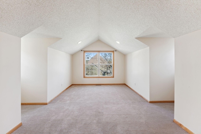 bonus room with baseboards, carpet, vaulted ceiling, and a textured ceiling