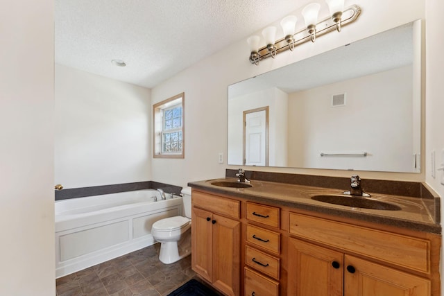 full bathroom featuring a sink, a bath, and a textured ceiling