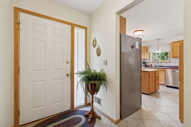 11521 Poppy St NW, Coon Rapids, MN 55433 - foyer featuring light tile patterned floors and baseboards
