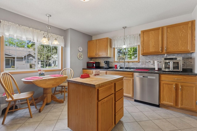 11521 Poppy St NW, Coon Rapids, MN 55433 - kitchen featuring stainless steel dishwasher, a sink, backsplash, butcher block counters, and light tile patterned flooring
