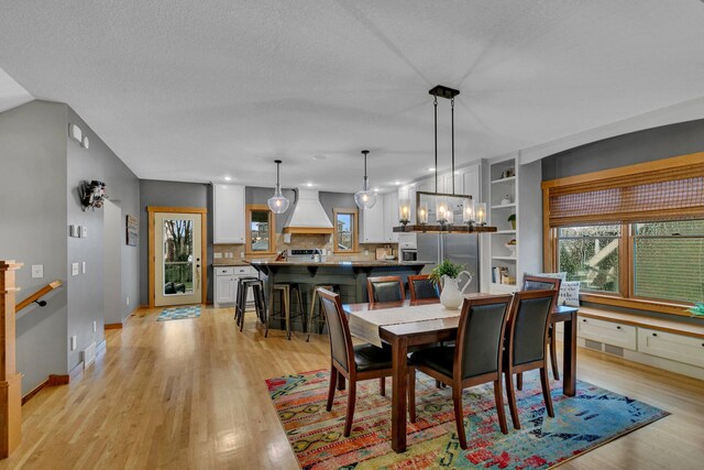 912 21st Ave N, Sartell, MN 56377 - dining space featuring light wood-style floors, baseboards, and an inviting chandelier