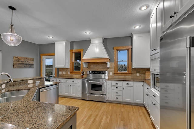 912 21st Ave N, Sartell, MN 56377 - kitchen featuring custom exhaust hood, white cabinets, a sink, appliances with stainless steel finishes, and backsplash