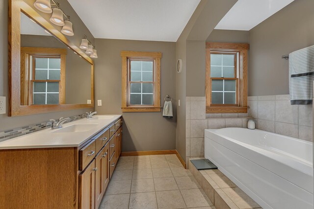912 21st Ave N, Sartell, MN 56377 - full bathroom with a sink, double vanity, tile patterned floors, baseboards, and a garden tub