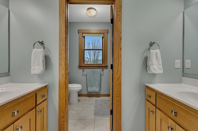 912 21st Ave N, Sartell, MN 56377 - full bathroom with toilet, baseboards, two vanities, and tile patterned flooring