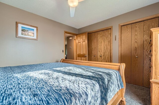 bedroom with carpet floors, a ceiling fan, and multiple closets