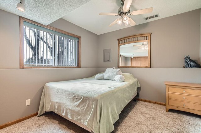 carpeted bedroom featuring baseboards, a ceiling fan, and visible vents