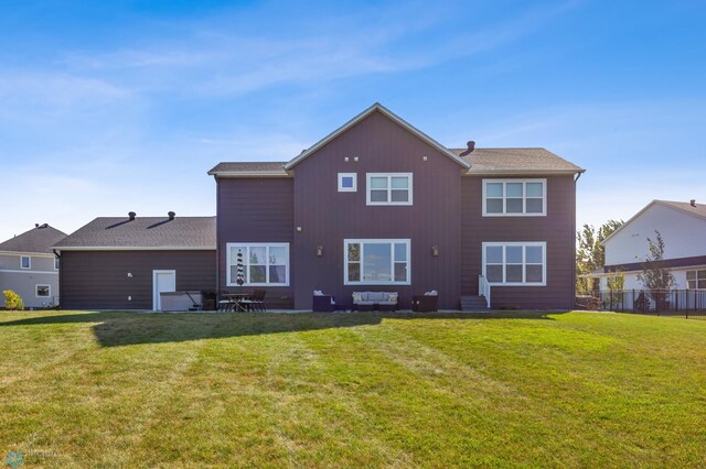 back of house with a lawn and fence
