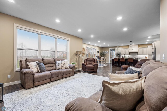 living room with recessed lighting, baseboards, and dark wood-style floors