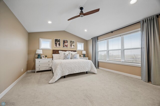 bedroom with baseboards, light colored carpet, multiple windows, and vaulted ceiling