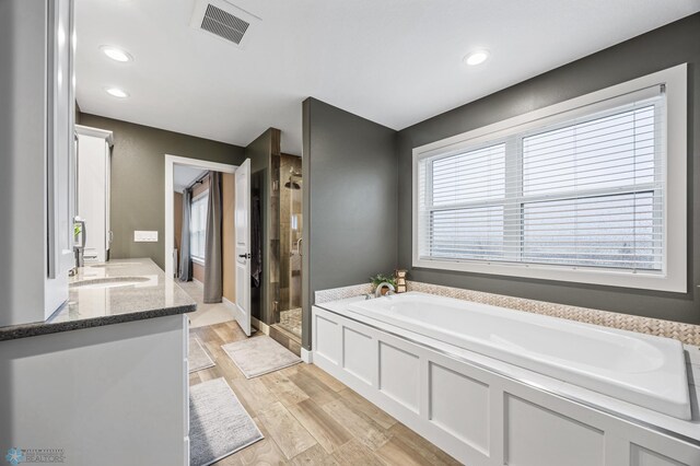 bathroom with visible vents, wood finished floors, recessed lighting, a bath, and a shower stall