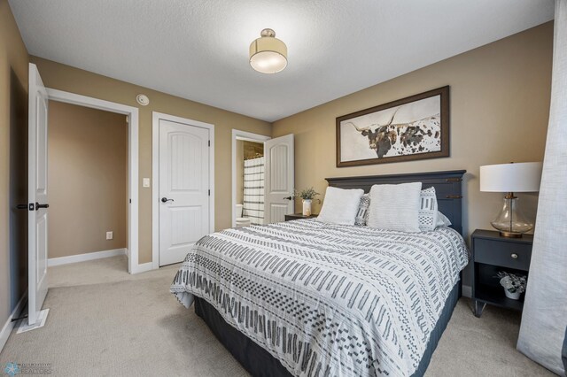 bedroom featuring baseboards and light carpet