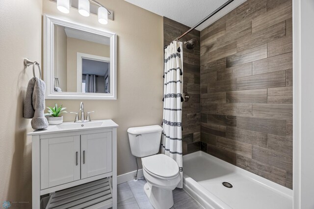 full bathroom featuring vanity, toilet, and tiled shower