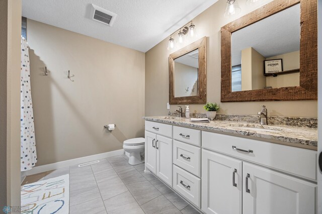 full bath featuring a sink, double vanity, toilet, baseboards, and visible vents