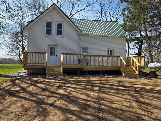 back of house with a deck and metal roof