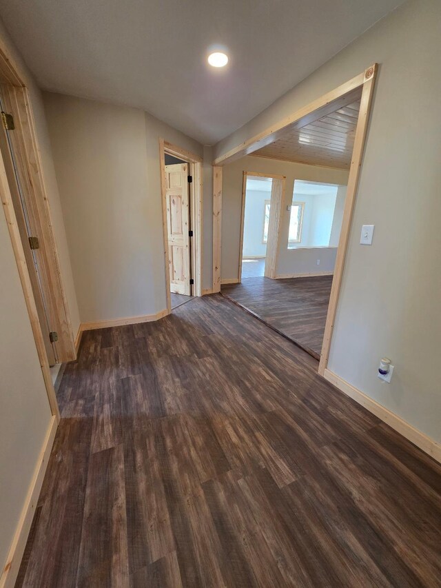 unfurnished room with baseboards and wood finished floors