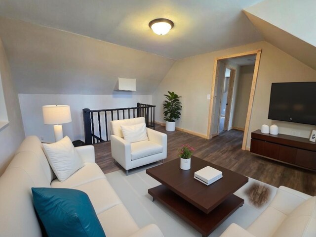 living room featuring baseboards, wood finished floors, and lofted ceiling