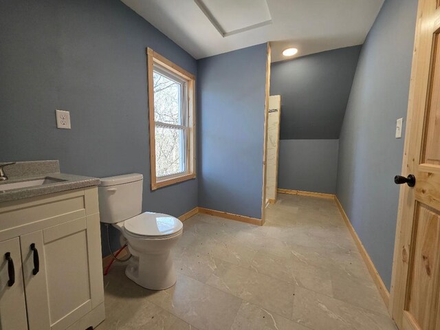half bath with baseboards, vanity, toilet, and lofted ceiling