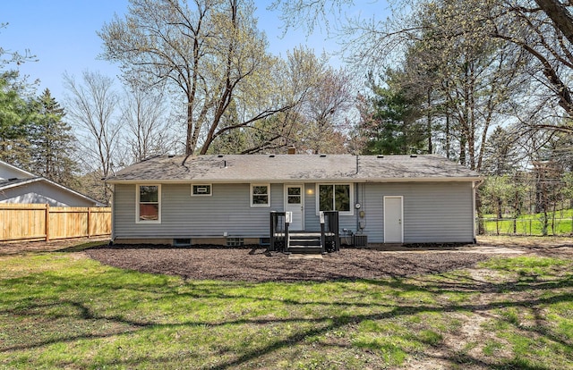 back of property with a yard and fence
