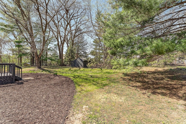 view of yard featuring an outbuilding, a shed, and a wooden deck