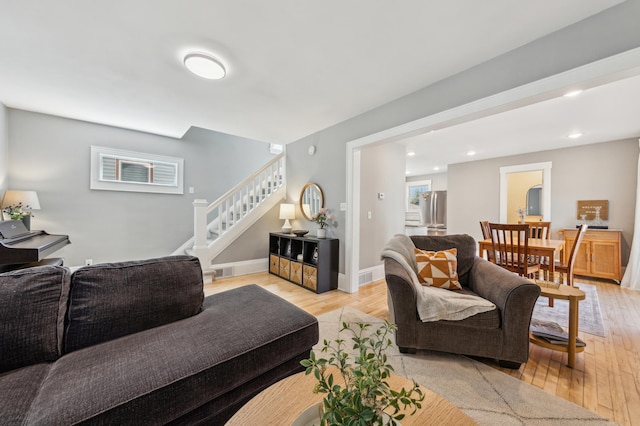 living area featuring light wood-style floors, stairway, visible vents, and recessed lighting