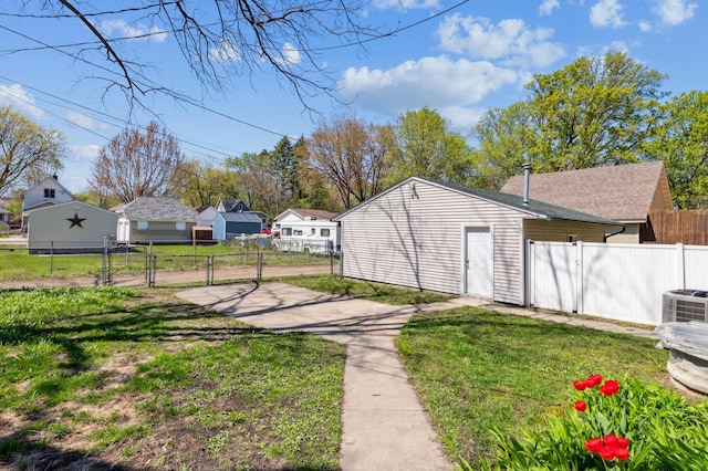 view of yard featuring a gate, fence, a residential view, and central AC unit