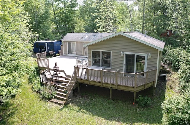 A6 Pathfinder Vlg, Hinckley, MN 55037 - back of property featuring stairs, a deck, central AC unit, a shingled roof, and a view of trees