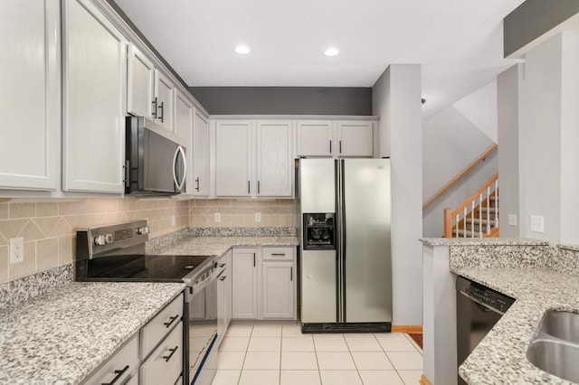 kitchen featuring stainless steel appliances, tasteful backsplash, light stone countertops, and recessed lighting