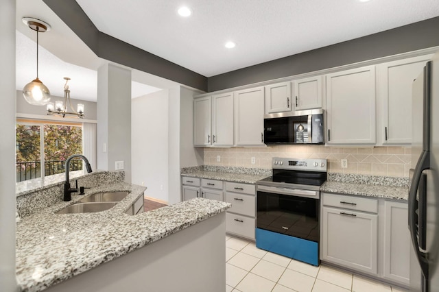 kitchen featuring appliances with stainless steel finishes, a sink, tasteful backsplash, light stone counters, and light tile patterned floors