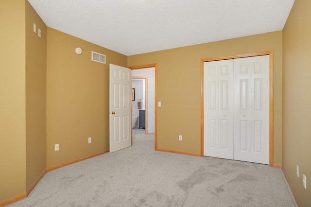 unfurnished bedroom with carpet flooring, baseboards, a closet, and a textured ceiling
