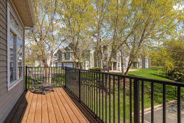 wooden terrace featuring a residential view and a yard