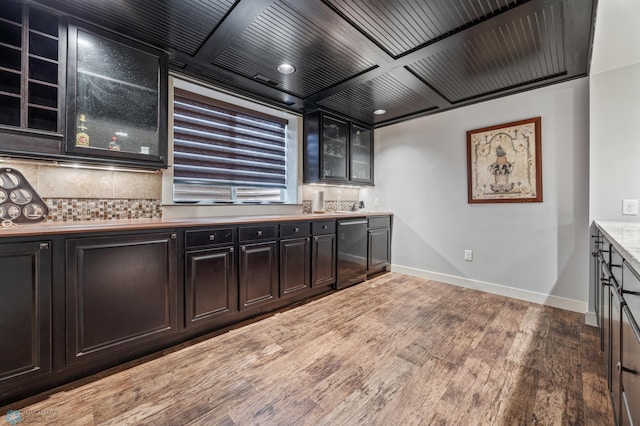 6028 Silverleaf Dr S, Fargo, ND 58104 - kitchen featuring backsplash, fridge, wood finished floors, baseboards, and glass insert cabinets
