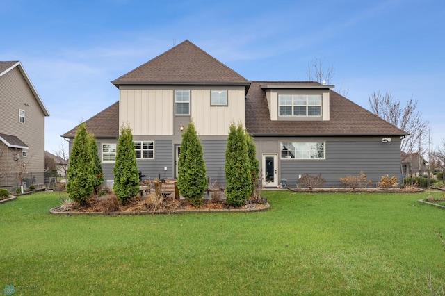 6028 Silverleaf Dr S, Fargo, ND 58104 - back of house featuring roof with shingles, board and batten siding, and a yard