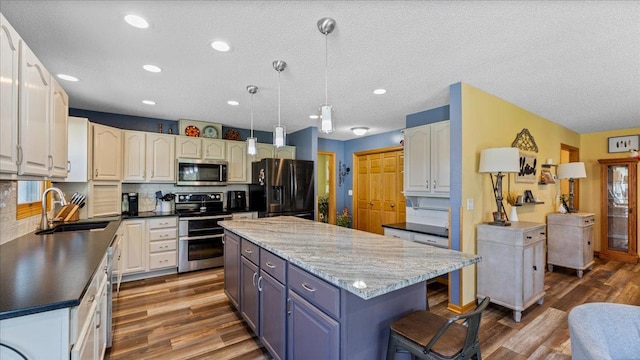 21151 150th St, Sauk Centre, MN 56378 - kitchen featuring stainless steel appliances, a sink, dark wood-style flooring, a center island, and recessed lighting